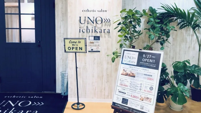 サロンの入口。紺色の扉と「UNO>>>ichikara」の看板