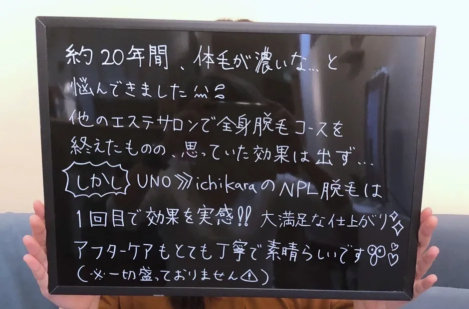手書きのボードを両手で持つお客様。顔は写っていません。